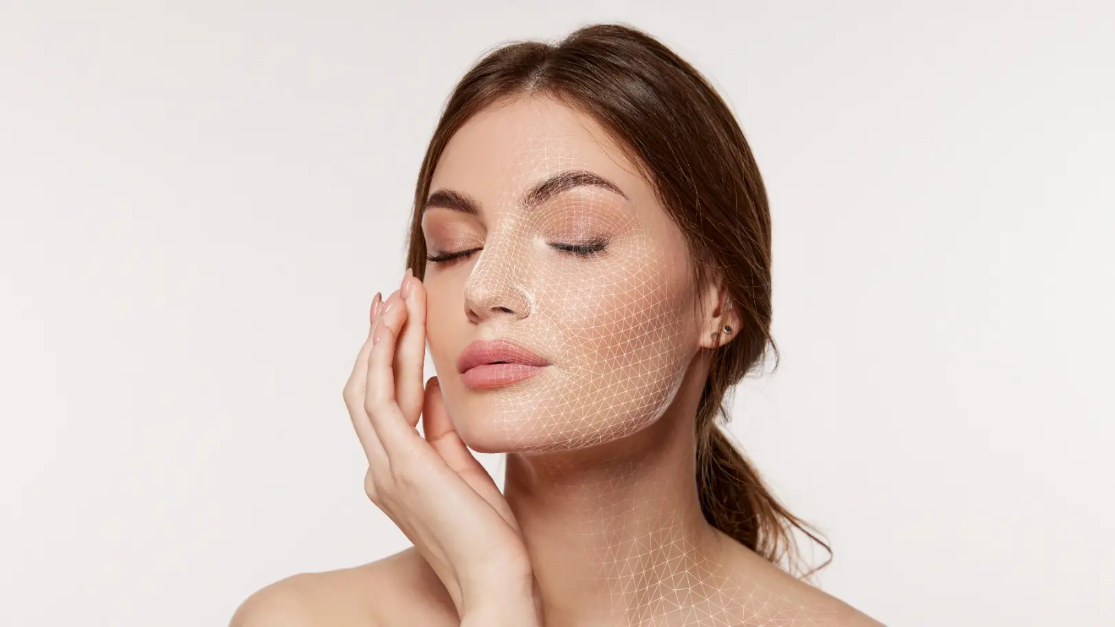 Woman touches her cheek with eyes closed while a geometric mesh overlay covers part of her face and neck.